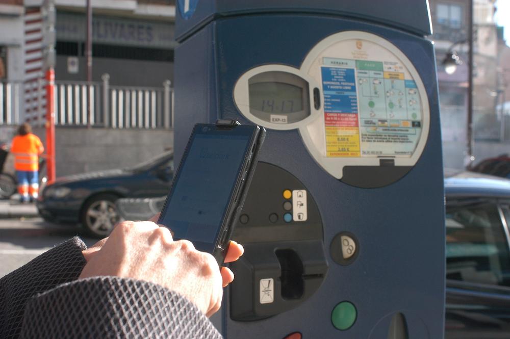 Una usuaria adquiere un vale de la ORA en la calle Real.